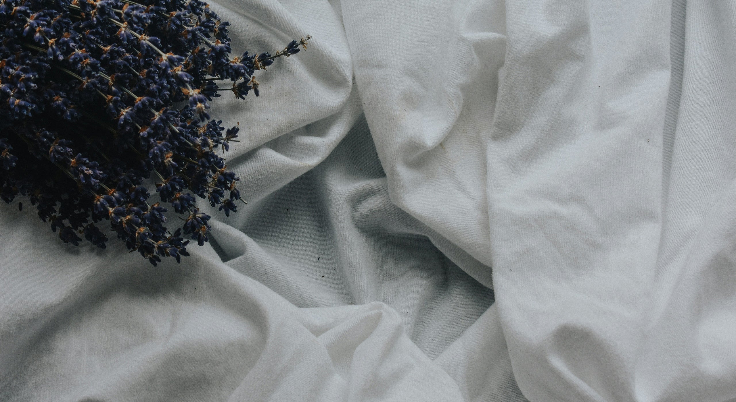 White fabric with a dark floral arrangement on a light gray background